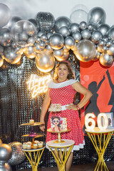 Woman celebrating her 60s birthday with themed decorations and cake