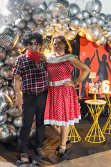 Couple wearing retro clothes posing at 60th birthday party
