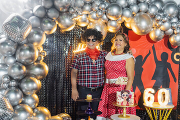 Fototapeta premium Senior couple celebrating 60th birthday with disco themed party