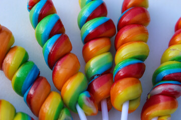 macro close-up of colorful rainbow lollipops isolated on a white background at an angle.