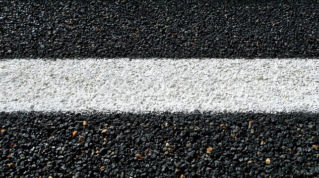 White painted line on a dark asphalt surface.