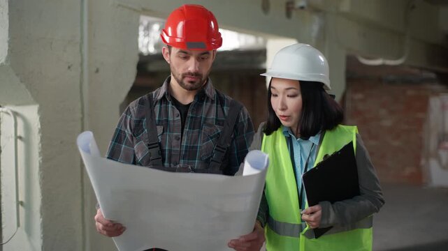 Business multiethnic builders man woman uniform brainstorming talking blueprint site Japanese businesswoman inspector hardhat Caucasian businessman hold paper project discuss construction contractors