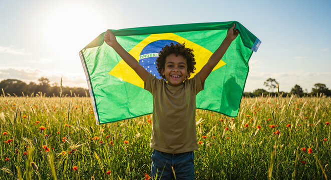 Menino feliz segurando bandeira do brasil no campo ensolarado dia da independ&ecirc;ncia brasil