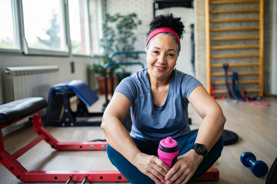 Active senior woman resting after gym workout with water bottle