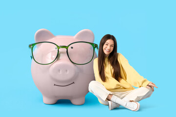 Piggy bank in eyeglasses on blue background