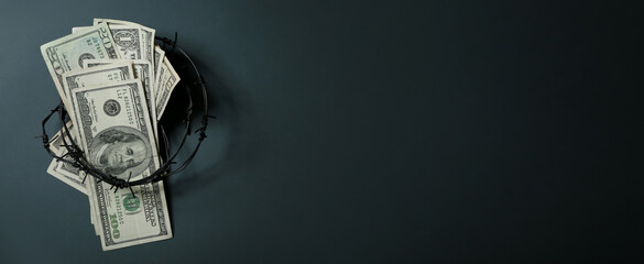 Dollar banknotes with barbed wire on dark background. Sanctions concept
