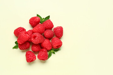 Heap of fresh raspberries and mint on light background