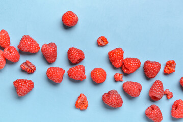 Many fresh raspberries on blue background