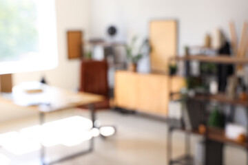 Blurred view of modern office with workplace and shelf units