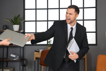 Bankrupt businessman giving away his laptop in office
