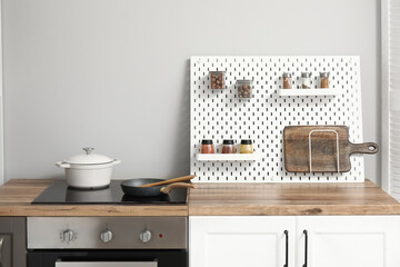 Stylish light kitchen with pegboard and kitchenware