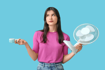 Young woman with different fans on blue background