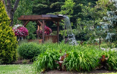Waterfall coming from the roof of a pergola in a botanical park