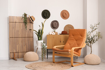 Interior of living room with wooden folding screen, armchair and commode