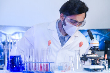 An Indian scientist in a lab coat carefully examines a sample during a pharmaceutical research and development process. Concept for scientific discovery and innovation.