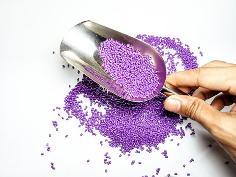 purple plastic masterbatch, polymer carries colorful pigments with small scoops poured into a white background, suitable for product catalog design of industrial plastic manufacturing company profiles