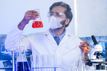 A dedicated Indian researcher analyzes a biological sample in a lab, contributing to medical...