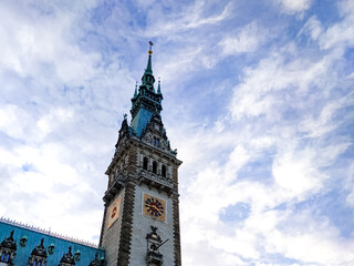 City Hall of Hamburg on a sunny day with bright blue sky and white clouds in the background. Historic architecture in the heart of the city.