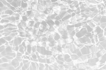 White water with ripples on the surface. Defocus blurred transparent white colored clear calm water surface texture with splashes and bubbles. Water waves with shining pattern texture background.