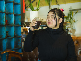 Young business woman manager asian one person sit on sofa smile cheerful hand holding tablet and smartphone talk happiness about work new project job online product sale marketing in cafe coffee shop