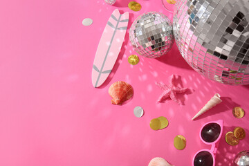 Disco balls with beach decor and confetti on pink background
