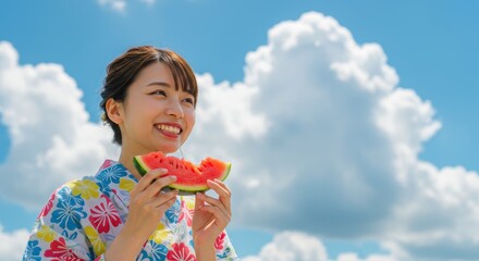 夏の青空の下でスイカを食べる浴衣姿の女性