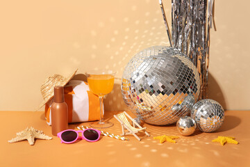 Disco balls with cocktail, tinsel and beach decor on color background