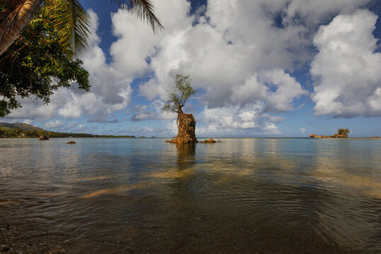 Sunrise at Apaca Point in Agat, Guam, aka Hagat, with still ocean waters, sandy beaches, and scattered clouds