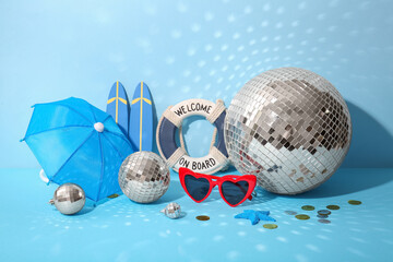 Disco balls with sunglasses, confetti and beach decor on blue background