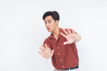 A terrified young Asian man backing away with his hands raised in fear, pleading for distance....