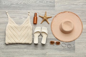 Female summer dress with shoes, hat and sunglasses on grey wooden background