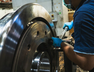 Close-up engineer technician craftsman one person hand wear glove safety protective holding wrench tool tighten torque nut standard value for job repair product in machine workshop industrial factory