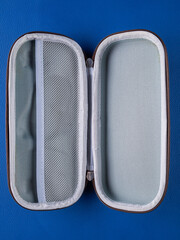 Close-up of a gray school pencil case in a hard format on a blue background