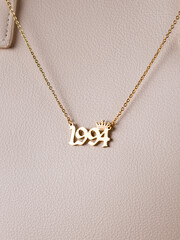 Close-up of a metallic gold pendant in the shape of 