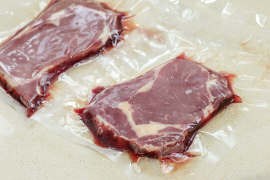 Vacuum-packed whole-cut ribeye steak during thawing