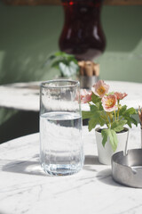 Fresh water and flowers on a marble table in a cafe