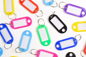 Colorful plastic key tag isolated on white background. Top view, flay lay