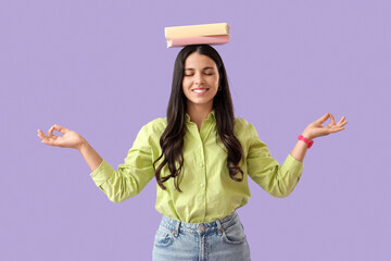Beautiful woman with books meditating on lilac background