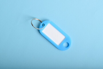 Light blue plastic key tag isolated on light blue background