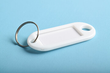 White plastic key tag isolated on light blue background