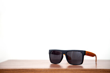 A pair of sunglasses on a wooden table. Sunglasses concept. Summer concept. 
Space for text.