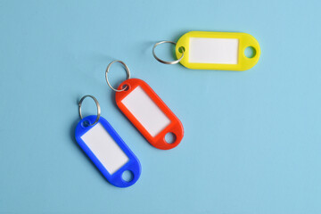 Colorful plastic key tag isolated on light blue background