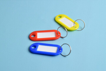 Colorful plastic key tag isolated on light blue background