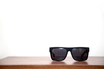 A pair of sunglasses on a wooden table. Sunglasses concept. Summer concept. 
Space for text.