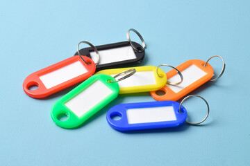 Colorful plastic key tag isolated on light blue background