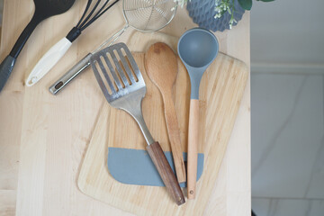 Cooking utensils arranged on wooden cutting board