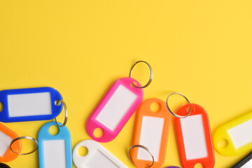 Colorful plastic key tag isolated on yellow background. Copy space. Copy space for your text and...