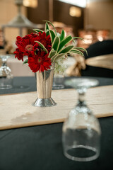 Red Gerbera Daisy centerpiece in a silver vase on a banquet table. Elegant floral arrangement for a...
