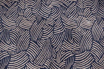 Abstract seamless pattern of a dark blue and beige carpet texture. Top-down view of woven fabric...