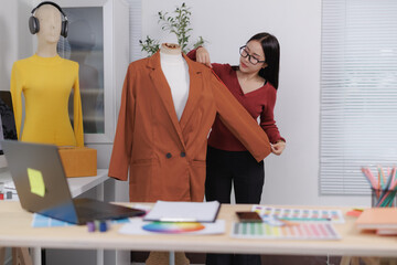 Fashion designer adjusting blazer on mannequin in creative office